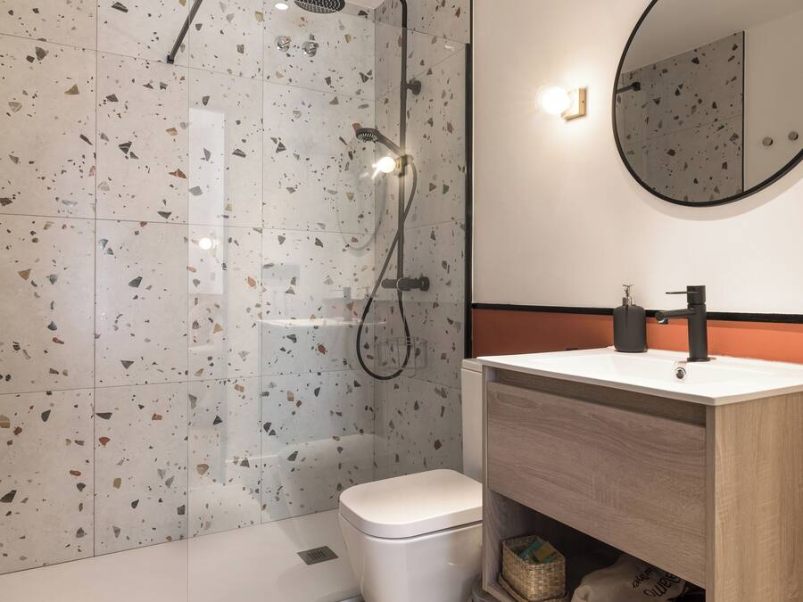 A modern bathroom with a shower, toilet, and vanity.