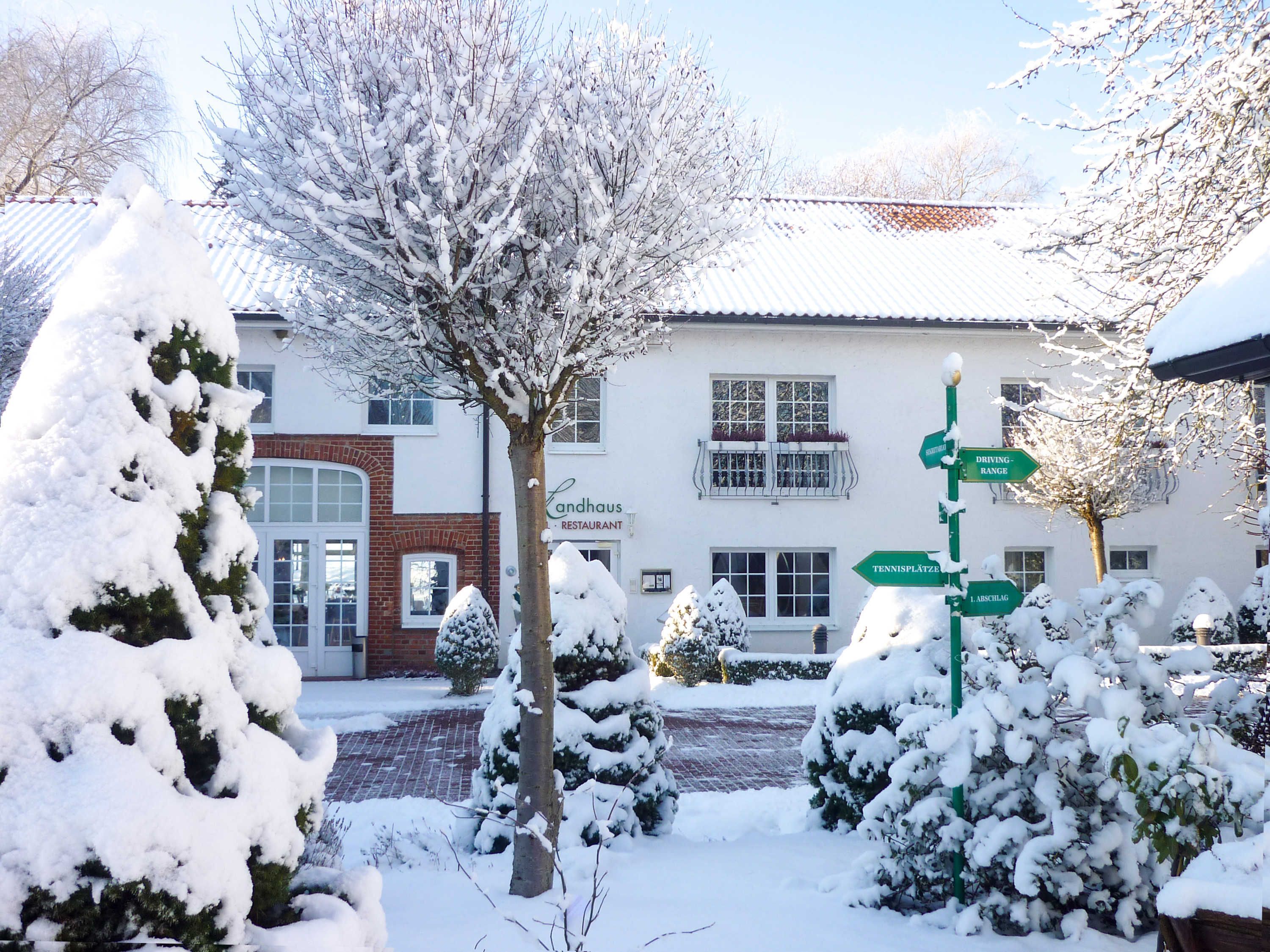 A snow-covered landscape with a signpost indicating directions to various locations.