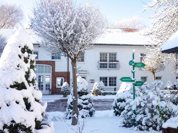 A snow-covered landscape with a signpost indicating directions to various locations.