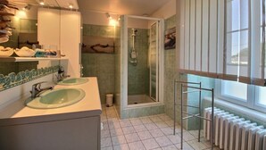 Un bagno moderno con due lavabi, una doccia e un'ampia finestra.