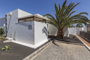 A modern building with a white exterior, a palm tree, and a sign reading 'CASA ELIAN.'
