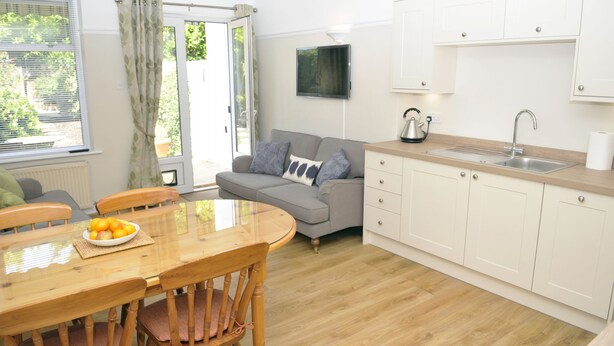 A modern kitchen with white cabinets, a wooden countertop, and a built-in sink. - Little Lane is a charming, recently refurbished 2 bedroom cottage sleeping 4 (Gosport)