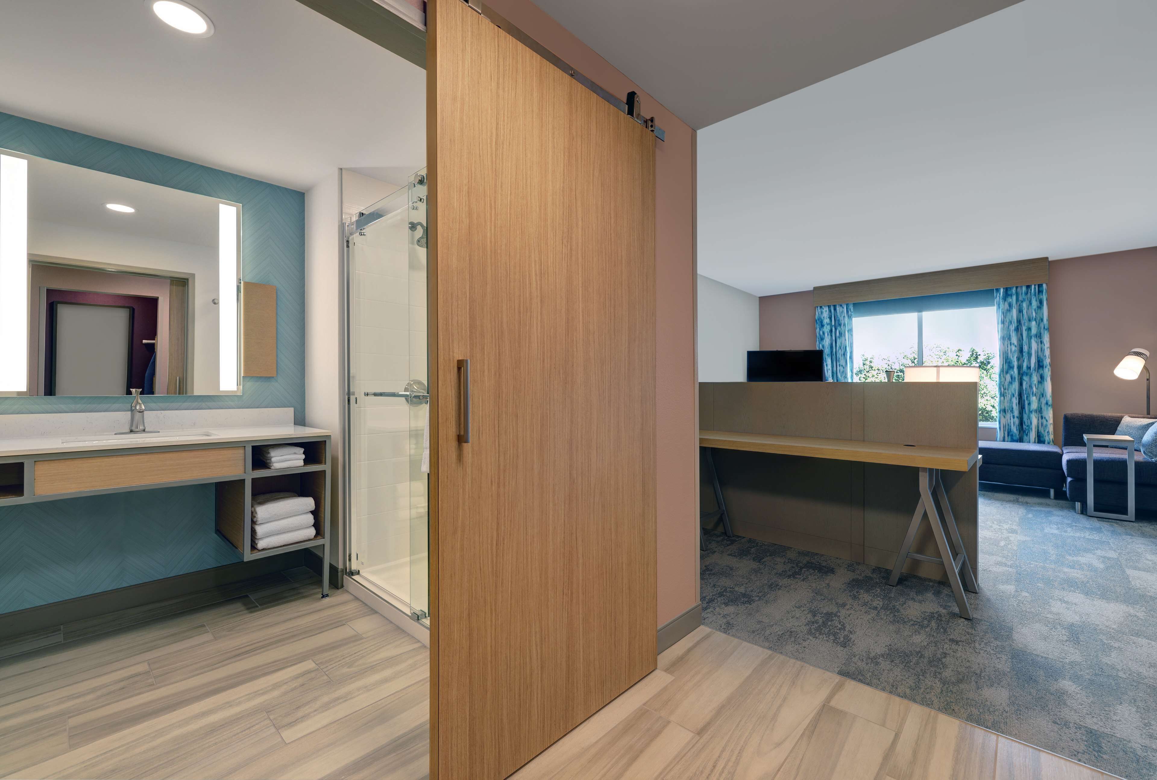 A modern bathroom with a shower, a vanity with a mirror, and a toilet.