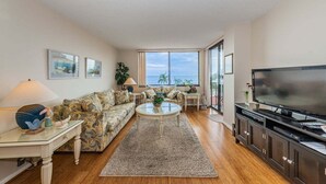 A living room with a sofa, coffee table, TV, and large windows. - PA C-401 - Palma - Standard Plus (St. Petersburg)