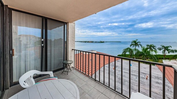 A balcony with a view of the sea, a table, and two chairs. - PA C-401 - Palma - Standard Plus (St. Petersburg)