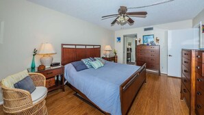 A bedroom with a bed, two bedside tables, a chair, a dresser, and a ceiling fan. - PA C-401 - Palma - Standard Plus (St. Petersburg)