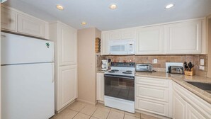 A kitchen with white cabinets, a refrigerator, a microwave, a stove, and a toaster. - PA C-401 - Palma - Standard Plus (St. Petersburg)
