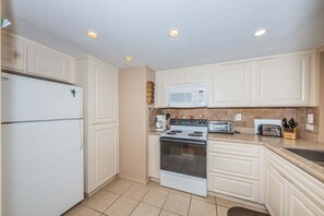 A kitchen with white cabinets, a refrigerator, a microwave, a stove, and a toaster. - PA C-401 - Palma - Standard Plus (St. Petersburg)