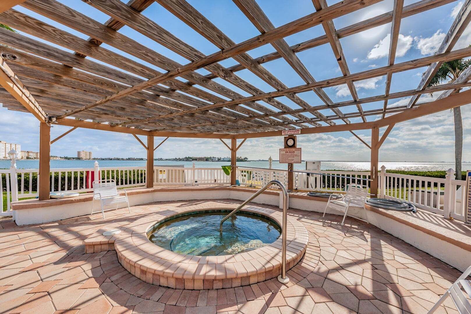 A covered outdoor hot tub area with a view of the water.