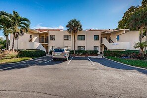 A multi-story building with a parking lot in front.