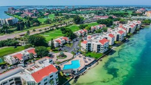 A coastal hotel with multiple buildings, a swimming pool, and a beach. - 2BR condo with golf course views, pool, hot tub, and balcony. (St. Petersburg)