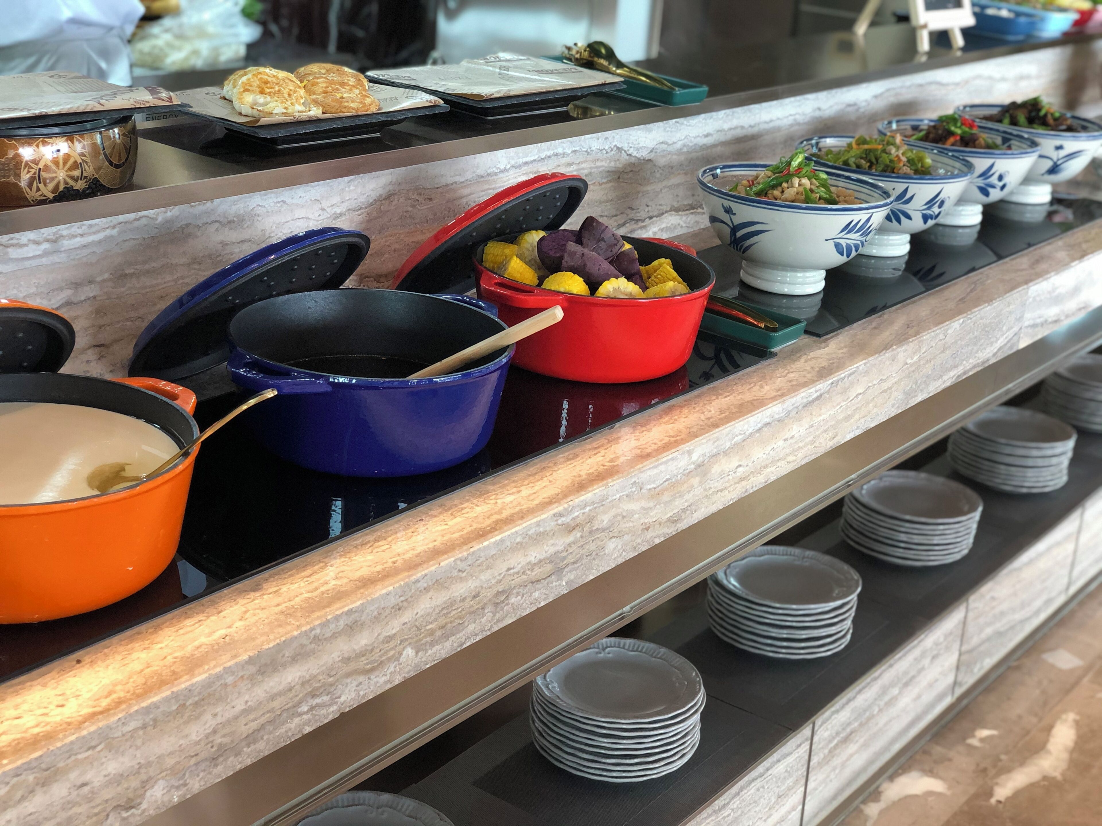 A buffet setup with various dishes and cooking pots.
