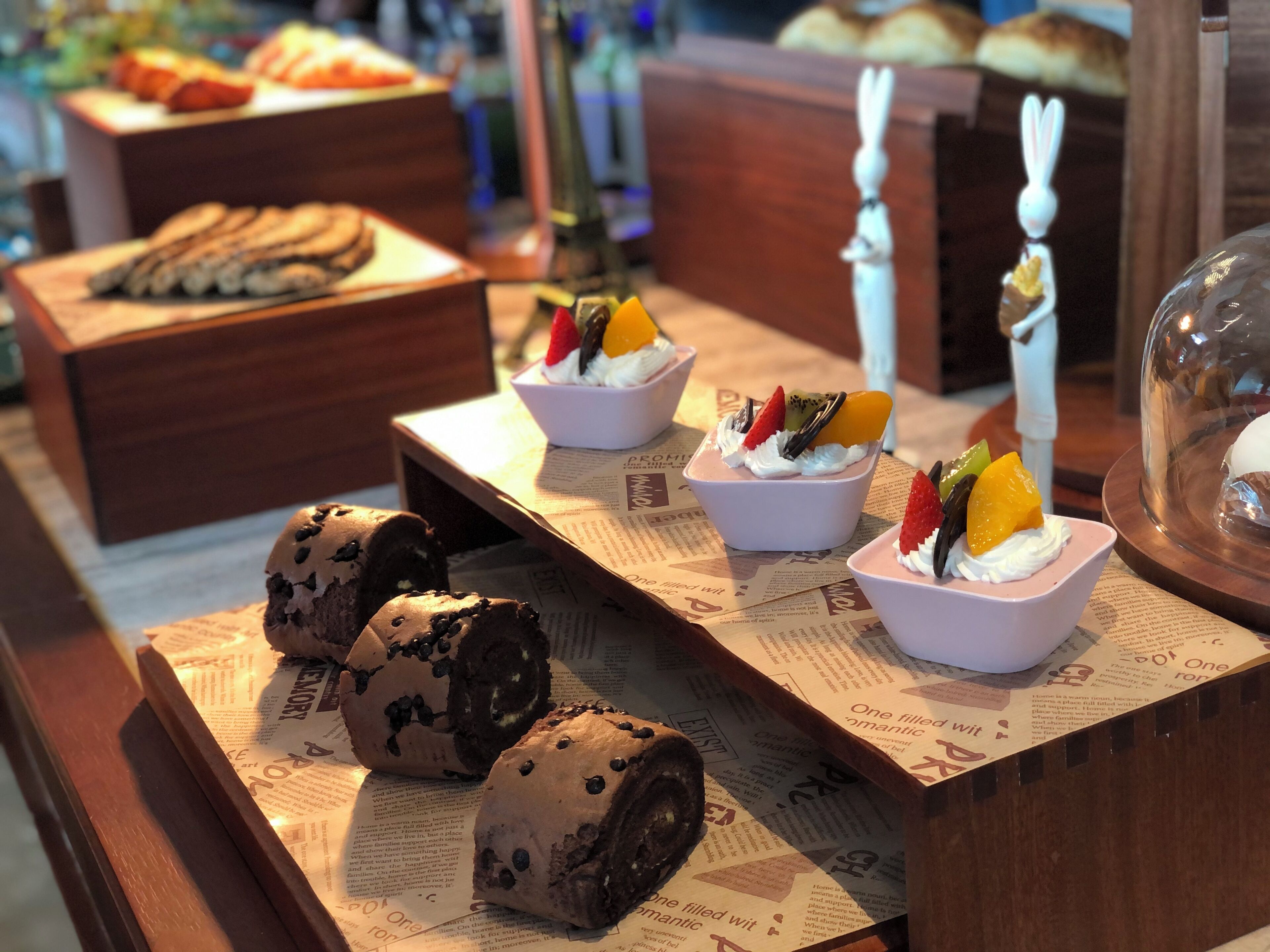 Una exhibición de postres con diversos dulces y pasteles sobre una mesa de madera.