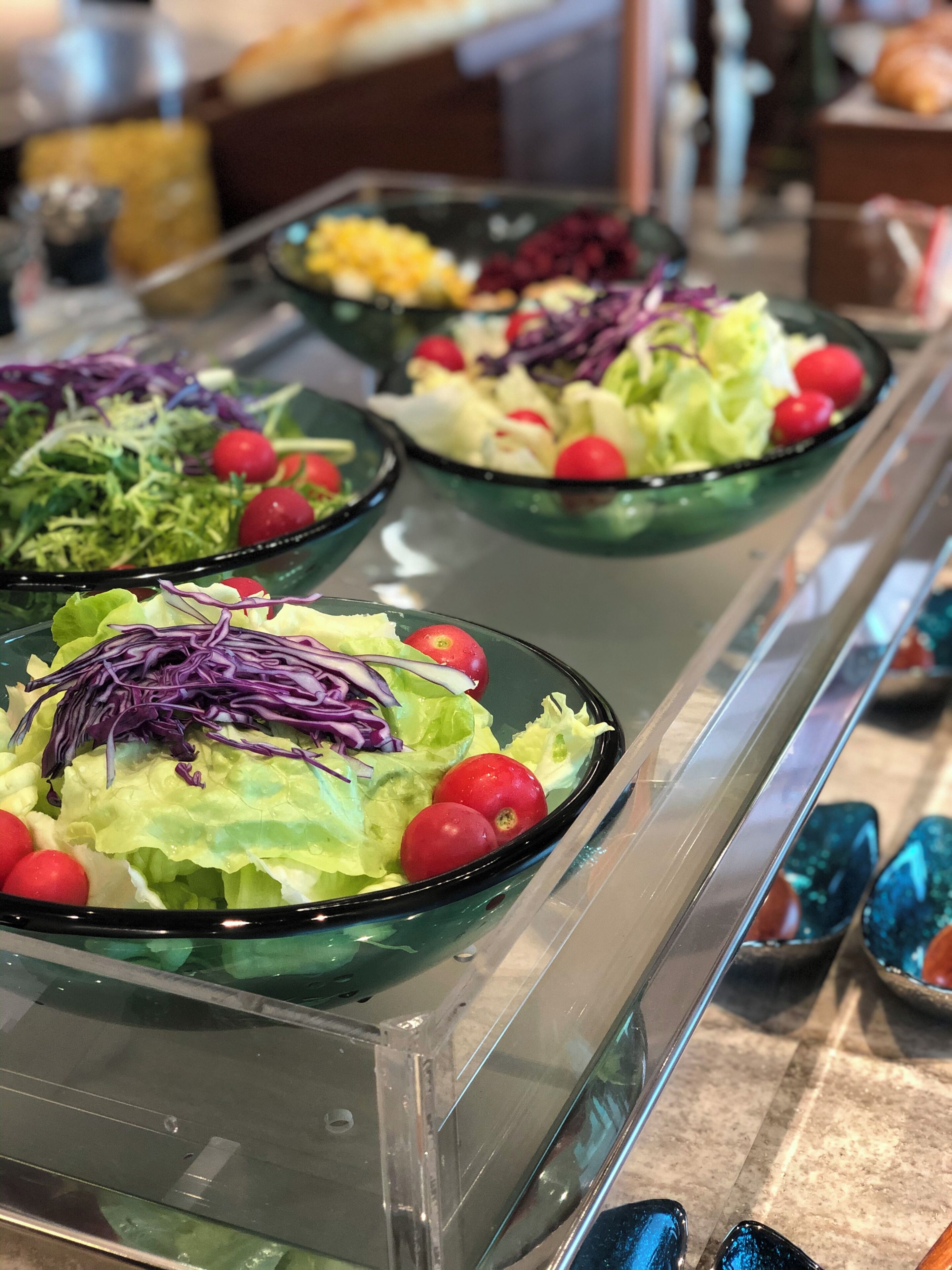 A buffet with various salads and fruits.