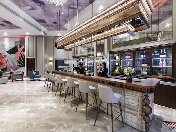 A bar area with a long counter, bar stools, and a bartender.