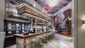 A bar area with a marble floor, a wooden bar counter, and a bartender. - Mercure Nantong Downtown (Nantong)