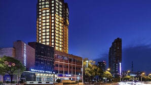 A high-rise hotel with illuminated windows, a modern facade, and a crosswalk in the foreground. - Mercure Nantong Downtown (Nantong)
