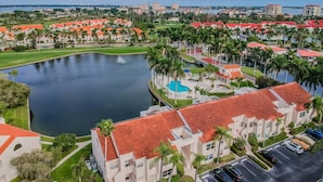 Una zona residencial con una gran masa de agua, edificios de techo rojo y un campo de golf.