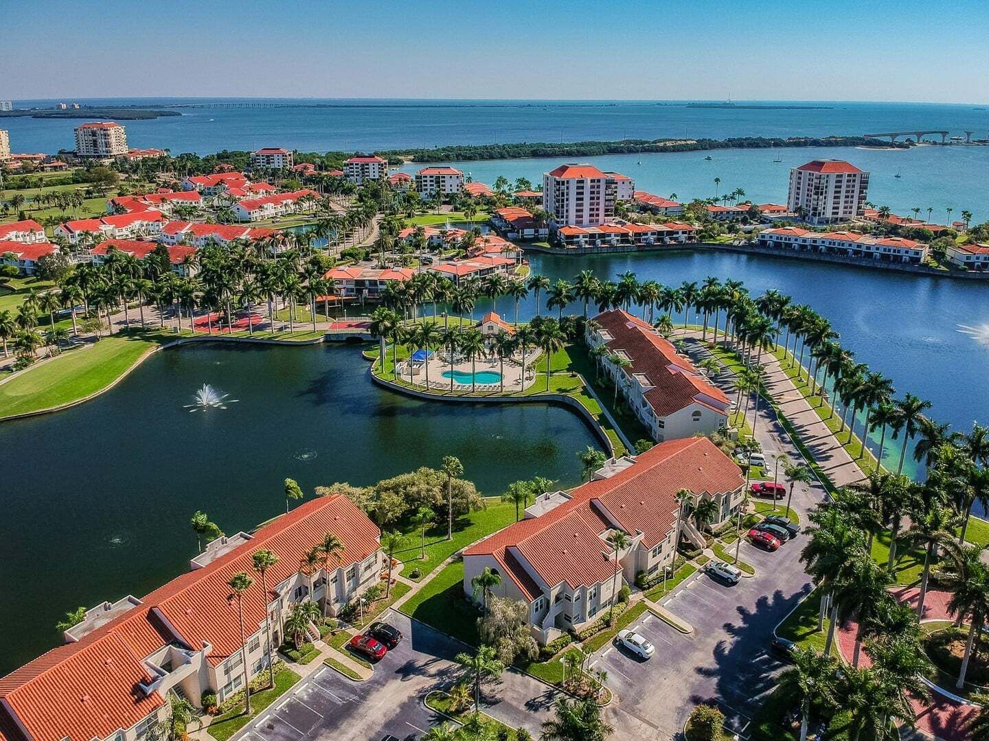 A resort with multiple buildings, a central water feature, and a marina.
