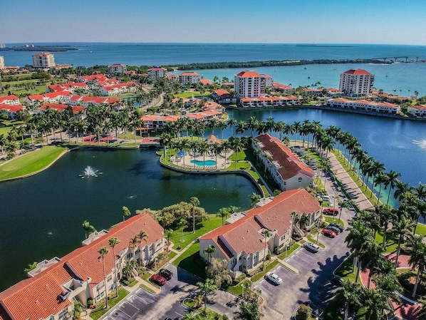Un resort con diversi edifici, una fontana centrale e un porto turistico.