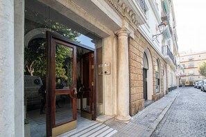 A hotel entrance with a wooden door and a stone facade. - Jardines de Candelaria Cadiz (Cádiz)