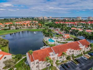Un quartier résidentiel caractérisé par un grand plan d’eau, des bâtiments aux toits rouges et un terrain de golf.