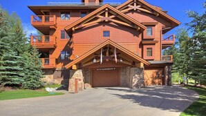 Un grand bâtiment en bois à plusieurs étages, doté de fondations en pierre, de nombreux balcons et d’une entrée de garage.
