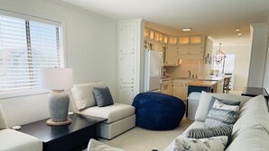 A modern living room with a sofa set, a coffee table, and a bean bag. - The Skipper 2 Bedroom Condo by RedAwning (Supply)