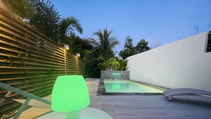 A modern outdoor patio with a pool, a green table lamp, and a white wall. - Villa Exotic Life, 2 bedrooms, heated pool (Le Moule)