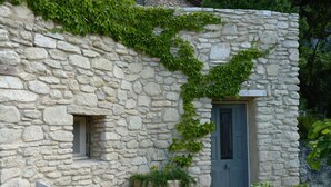 Un bâtiment en pierre doté d’une porte et d’une petite fenêtre.