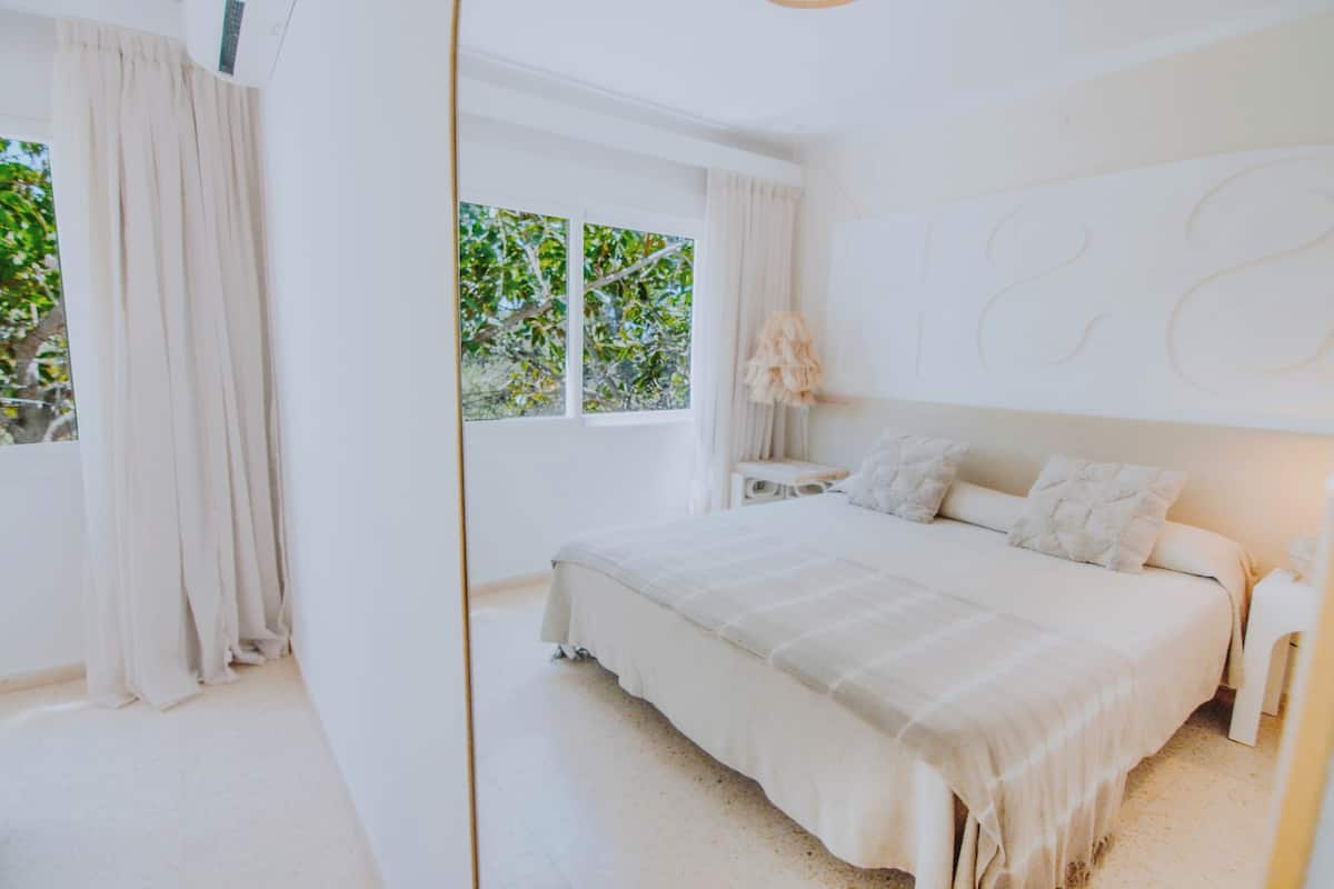 Un dormitorio con una cama grande, una ventana con cortinas y una pared con un diseño numérico.