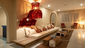 A modern living room with a sofa, wooden coffee table, and a unique red chandelier. - Secret Oasis Ibiza- Adults Only (Sant Josep de sa Talaia)