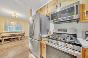Enjoy cooking in the well-equipped kitchen with a refrigerator, microwave, and gas stove, and dine at the adjacent table and bench.