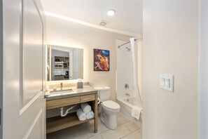 Een bad/douchecombinatie, designer toiletartikelen, een haardroger