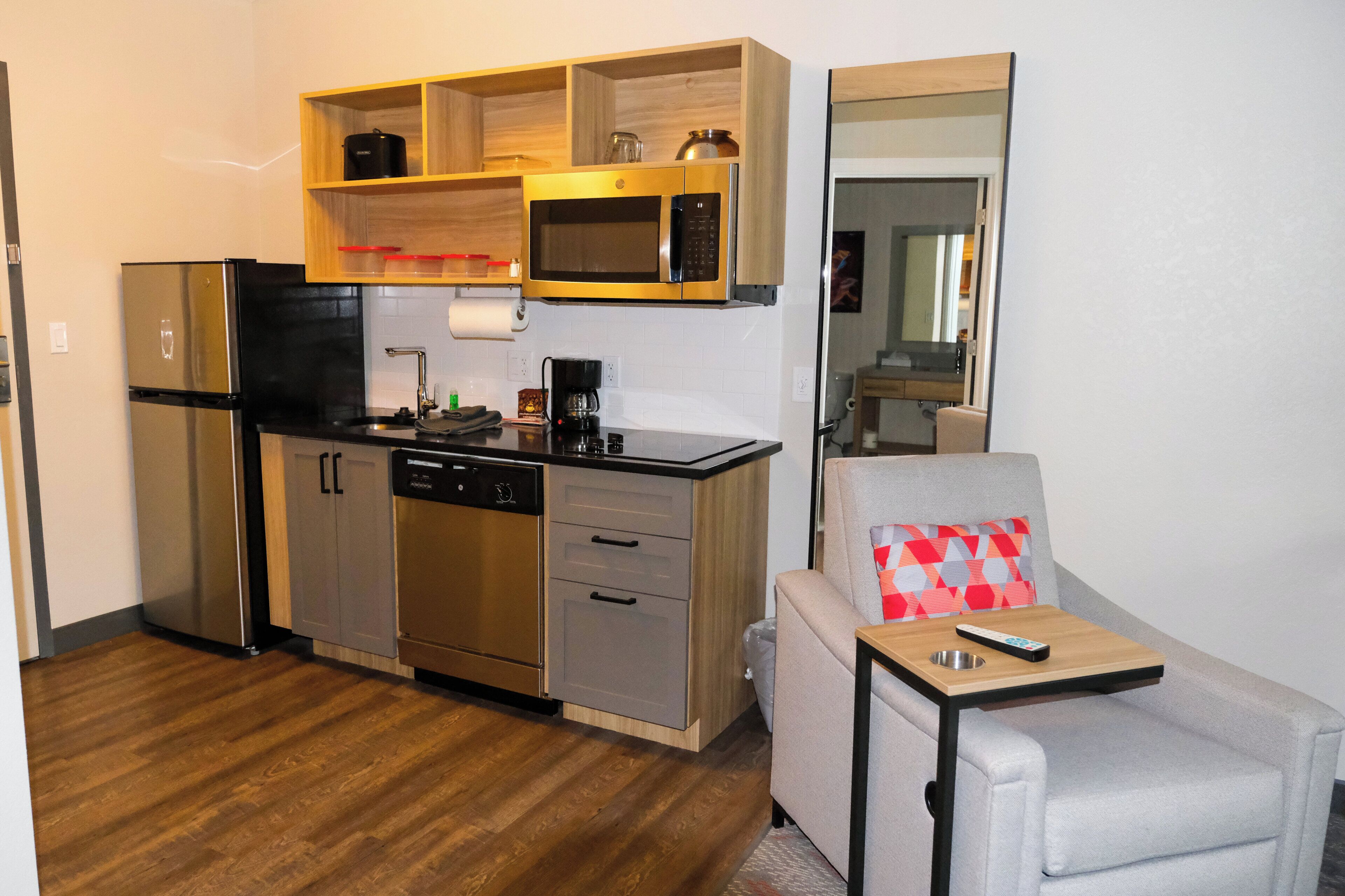 A compact kitchenette with a refrigerator, microwave, and coffee maker.
