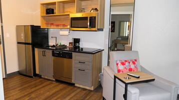 A compact kitchenette with a refrigerator, microwave, and coffee maker.