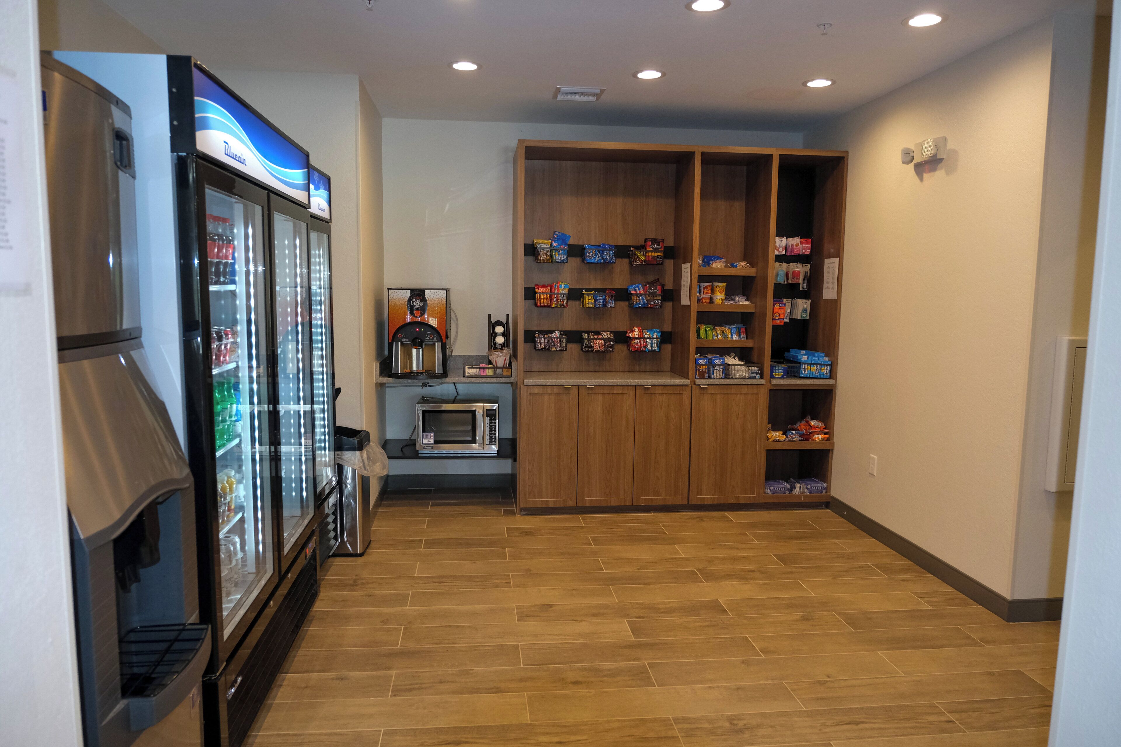 Una kitchenette equipada con refrigerador, microondas y cafetera.