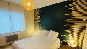 Un dormitorio moderno con una cama, una lámpara de pared y una mesita de noche con lámpara.