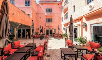 An indoor courtyard with a patterned floor, potted plants, and a statue. at Secret Garden Miami Beach