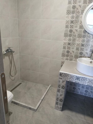 A bathroom with a shower, toilet, and sink. - Creta Sun Apartments (Ierapetra)