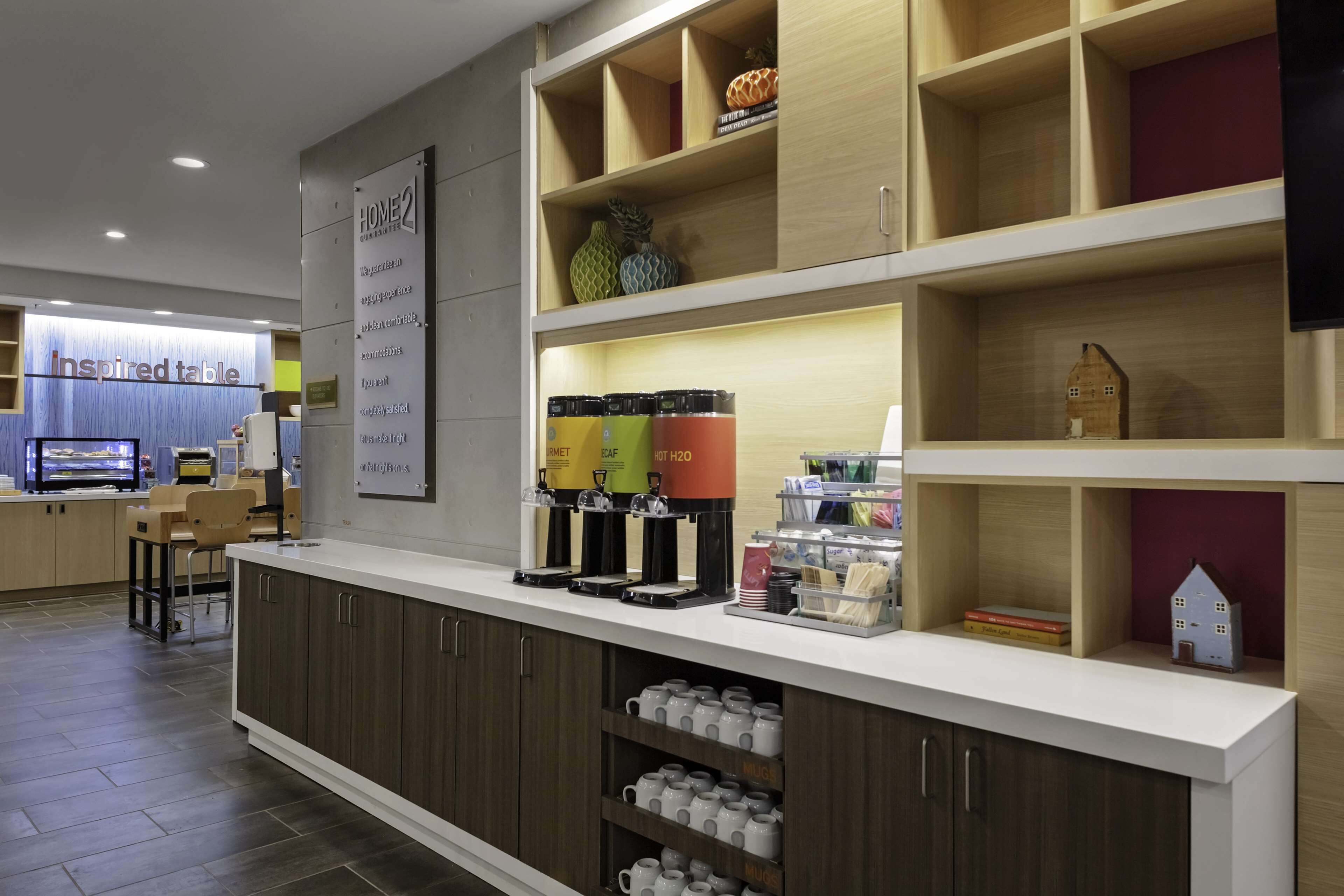 Uma área de recepção com balcão, placa informativa e exposição de bolsas de água quente.