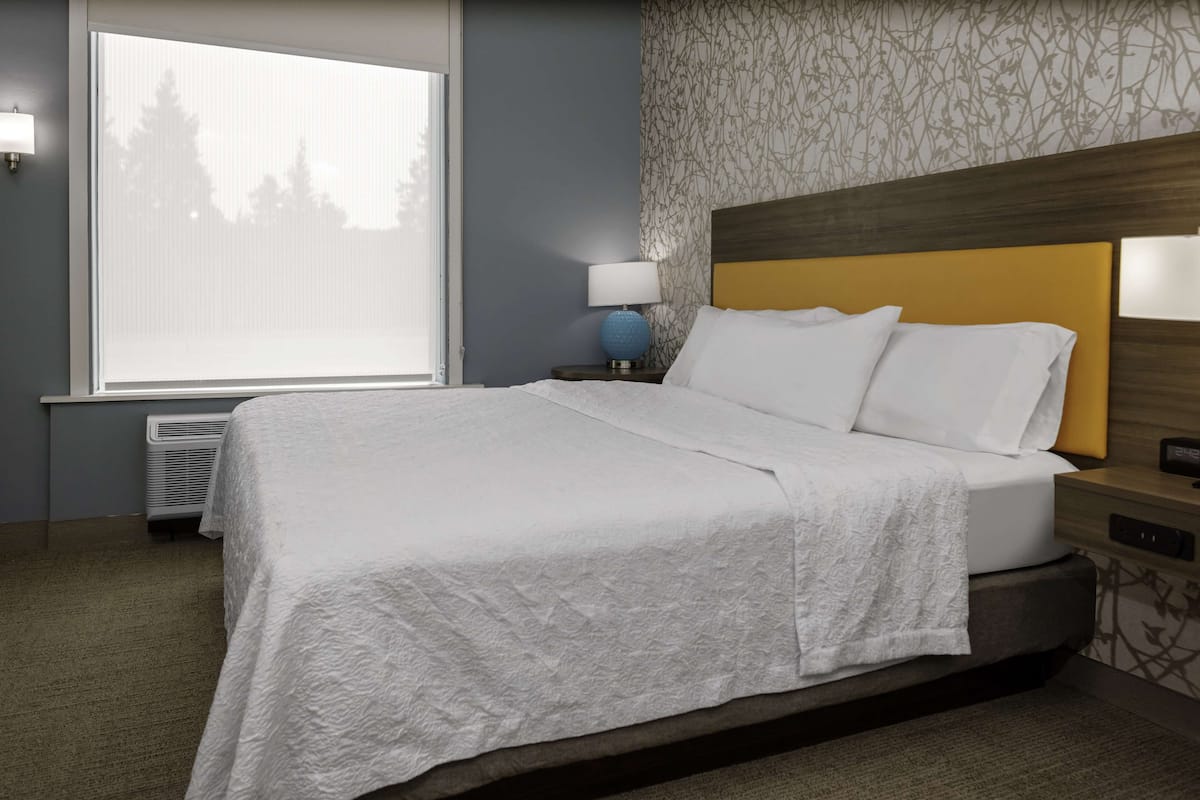 Ein ordentlich bezogenes Bett mit weißen Leinen in einem Hotelzimmer.
