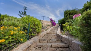 A stone staircase leading up to a stone wall with a metal railing. - Charming retreat with panoramic private pool, 300m from the sea (Trinità d'Agultu e Vignola)