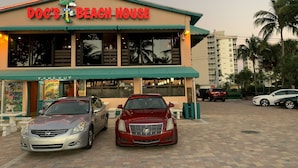 A building with a sign reading "Doc's Beach House" and a "Take Out" sign. There are two cars parked in front. - Beach, Shelling, Water Sport, Restaurant Right Across The Street!  Paradise!! (Bonita Springs)