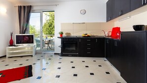 A modern kitchen with black cabinets, a marble countertop, and a built-in oven. - Apartment Adria 1 on the island Krk (Malinska)