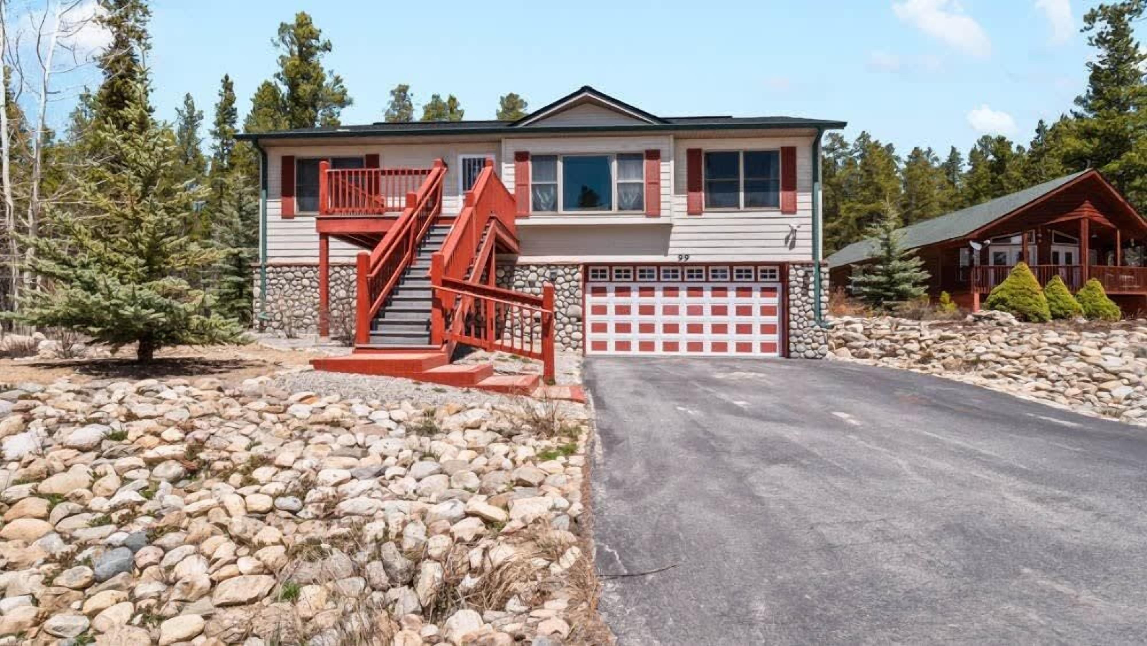 A two-story house with a red staircase, a garage, and a driveway.