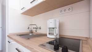 A modern kitchen with a built-in stove, a sink, and a coffee maker. - Apartment Jana in Malinska (Malinska)