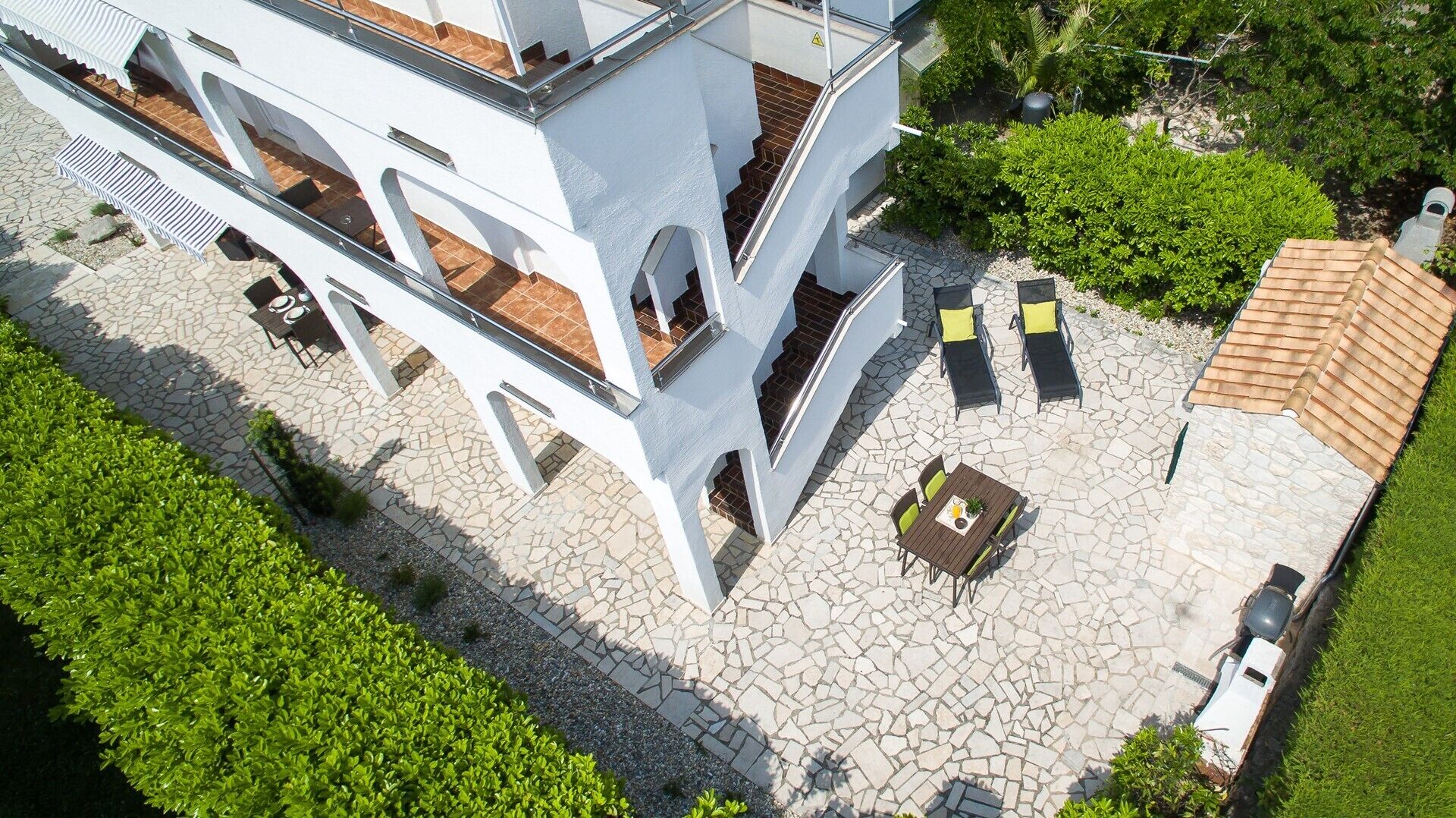 A modern building with a courtyard featuring outdoor seating and a tiled roof.