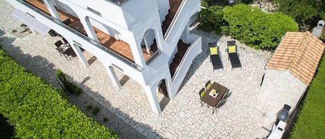A modern building with a courtyard featuring outdoor seating and a tiled roof.