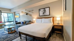 A hotel room with a large bed, a sofa, a small table, and a window. - Cozy Studio condo close to skiing, hiking and biking trails! (Keystone)
